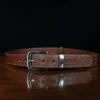 An American Alligator Belt with Nickel hardware showing the front view on a wooden table with black background - id 002