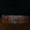 An American Alligator Belt with Nickel hardware showing the side view on a wooden table with black background - id 002