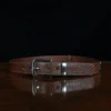 An American Alligator Belt with Nickel hardware showing the front view on a wooden table with black background - id 002