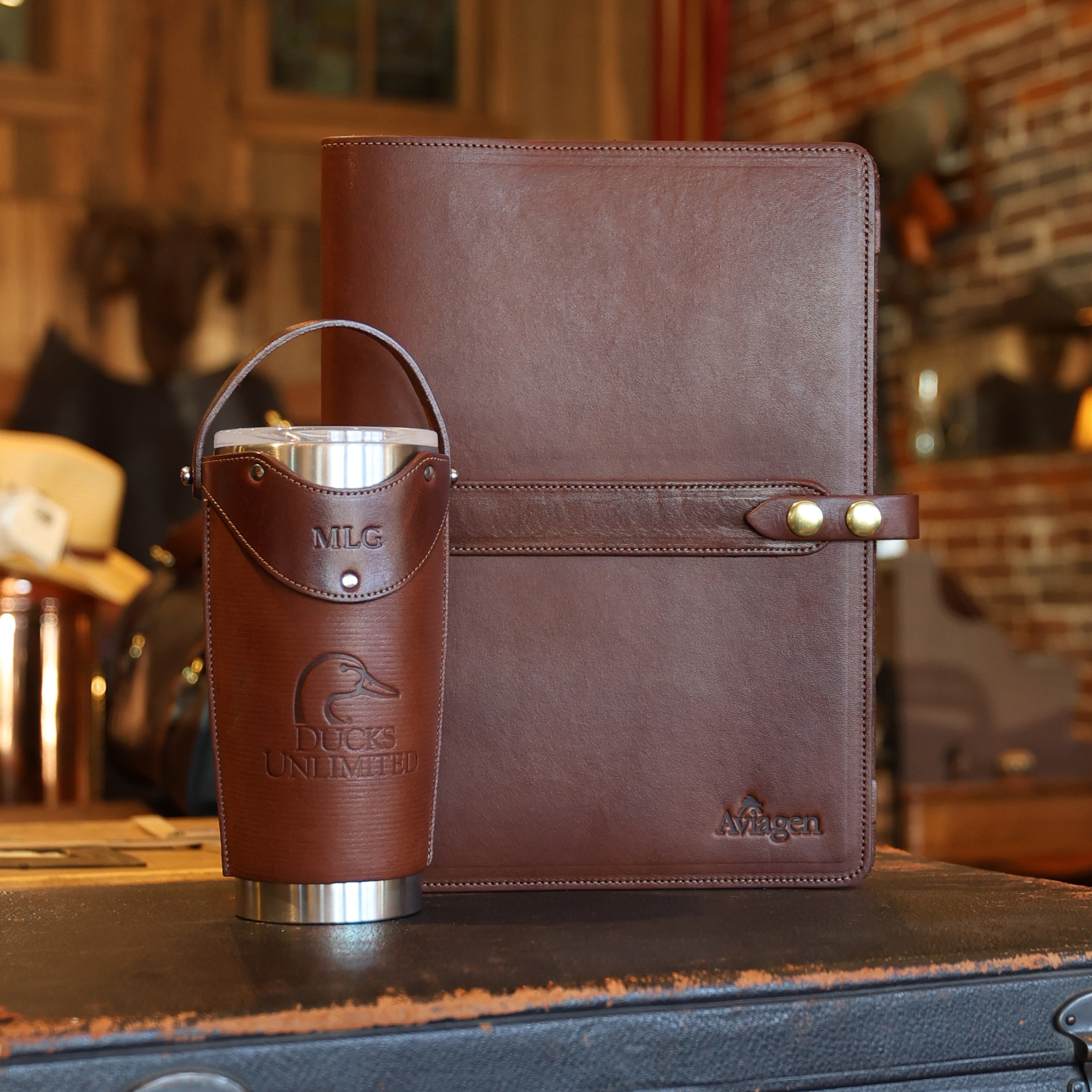 a No. 18 Portfolio and A tumbler sleeve with a corporate logo
