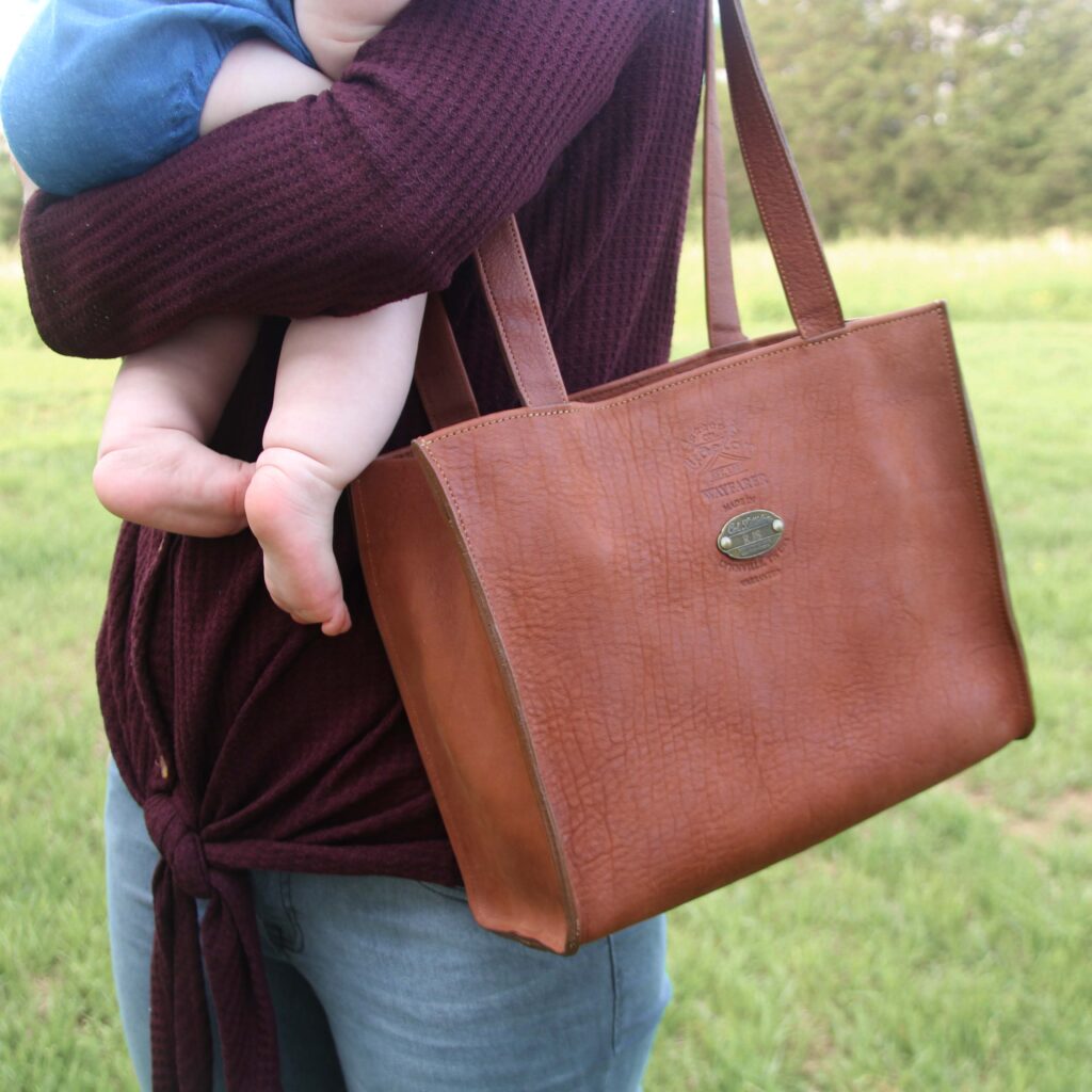 Wayfarer Tote being carried by woman holding a baby