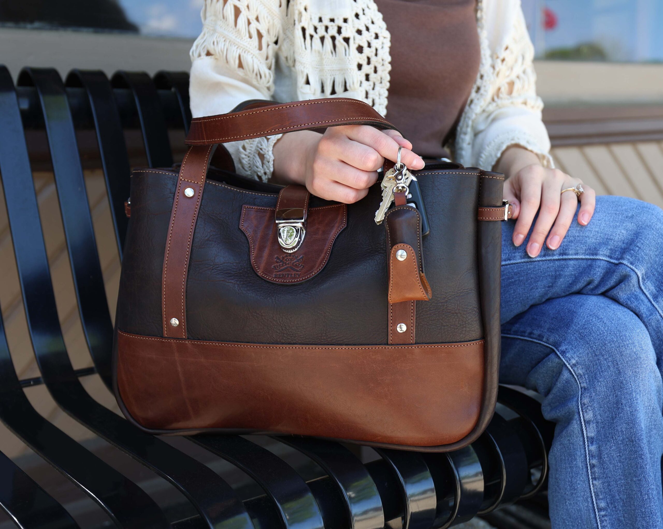 woman sitting on a bench with the Lip Balm Holder and Bentley Tote in American Buffalo, trimmed in American Steerhide.