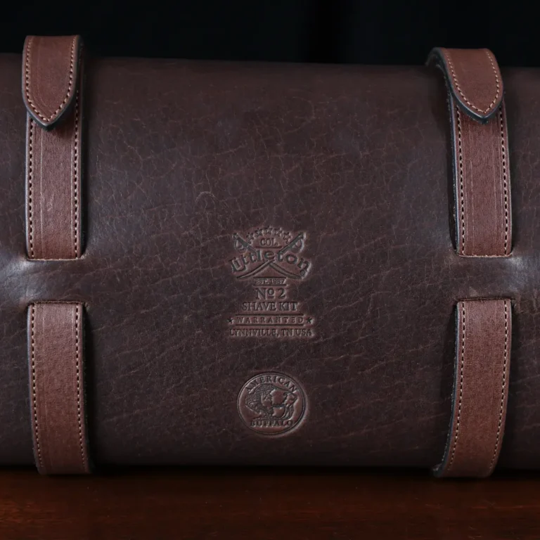 No. 2 Shave Dopp Kit in tobacco buffalo with No. 8 Khaki Cotton Canvas Lining - logo view on a wooden table
