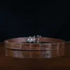 An American Alligator Belt with Nickel hardware showing the back view on a wooden table with black background - id 002