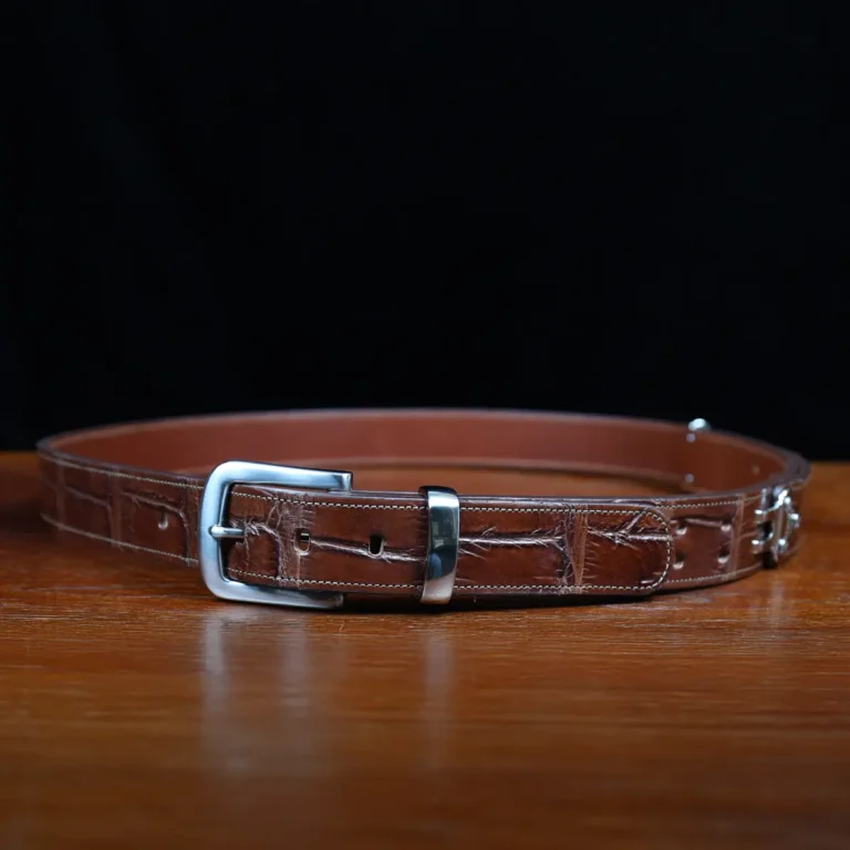 An American Alligator Belt with Nickel hardware showing the front view on a wooden table with black background - id 002