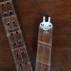 An American Alligator Belt with Nickel hardware showing the open hook view on a wooden table with black background - id 002