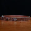 An American Alligator Belt with Nickel hardware showing the side view on a wooden table with black background - id 002