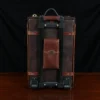 no 3 travel trunk in american buffalo - showing back with a dark background on wood table