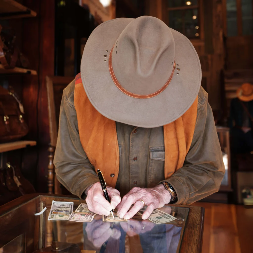 colonel signing money in the retail store for a promotion