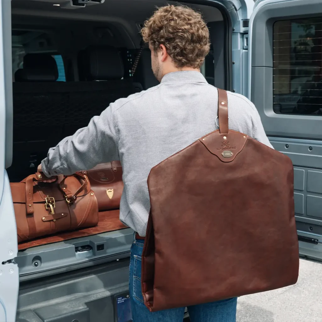 man holding a leather garment bag