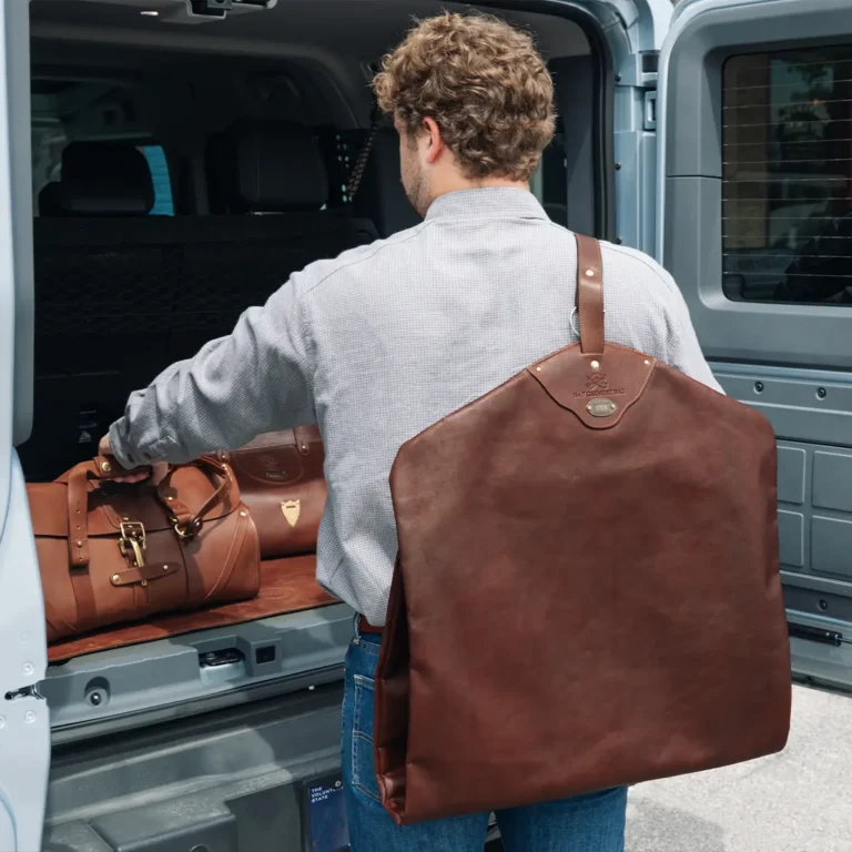 man holding a leather garment bag